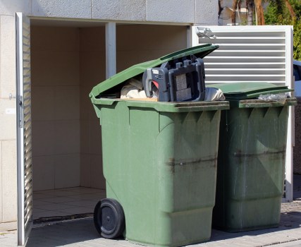 Entrance to a commercial waste depot in Notting Hill with signage indicating accessibility information